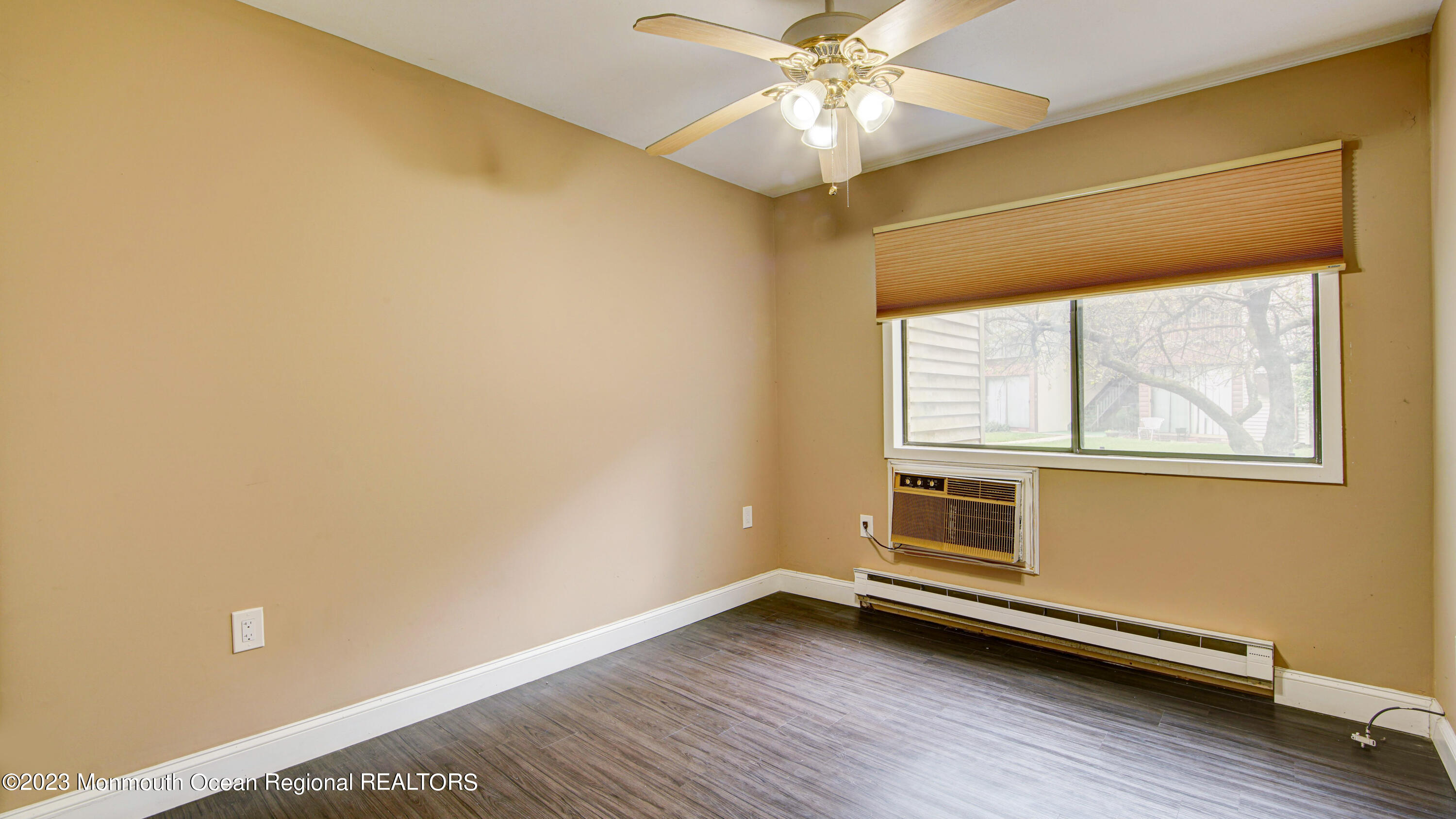 91 Arrowood Road, Unit B Manalapan, NJ 07726 - Photo 15 of 20 a view of an empty room with wooden floor and a window