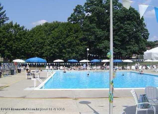 91 Arrowood Road, Unit B Manalapan, NJ 07726 - Photo 19 of 20 a view of a swimming pool with a patio