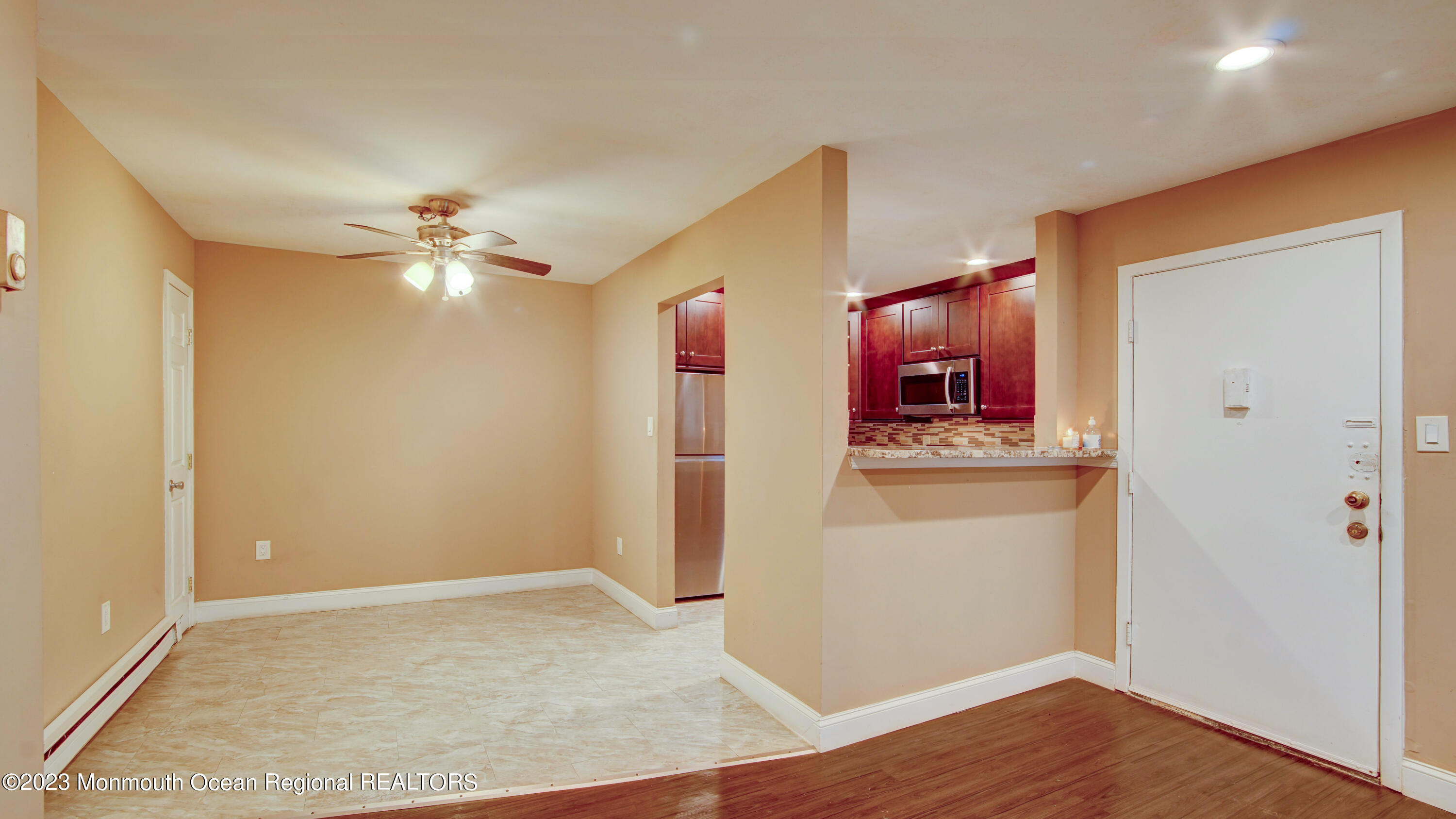 91 Arrowood Road, Unit B Manalapan, NJ 07726 - Photo 6 of 20 an empty room with wooden floor and cabinet