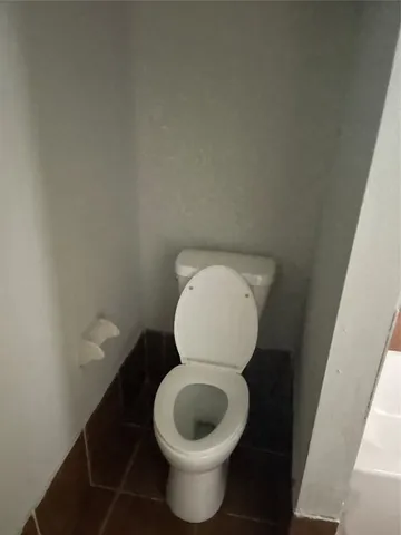 a toilet with a wooden floor and a sink