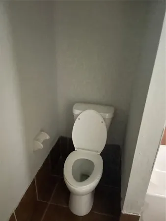 a toilet with a wooden floor and a sink