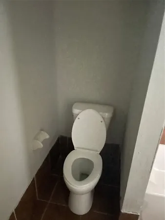 a toilet with a wooden floor and a sink