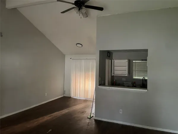 an empty room with a window and a ceiling fan