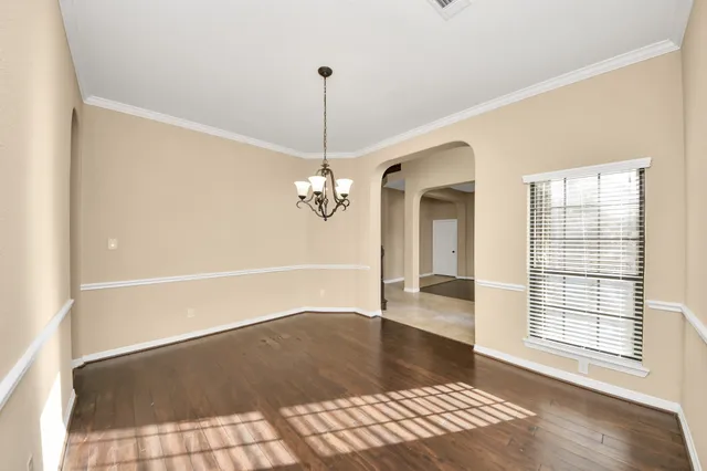 a view of a room with wooden floor and chandelier