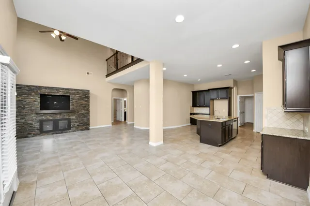 an empty room with windows and fireplace