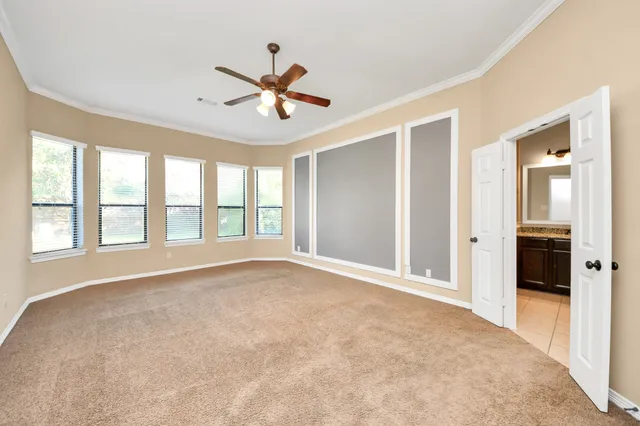 a view of an empty room with a chandelier fan