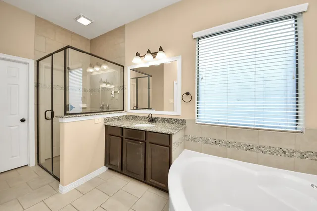 a bathroom with a tub sink and mirror