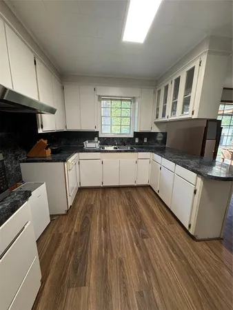 a kitchen with wooden floors and white appliances