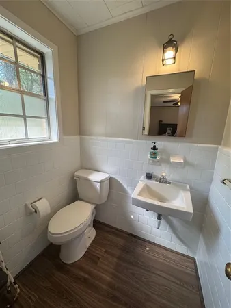 a bathroom with a toilet sink and mirror