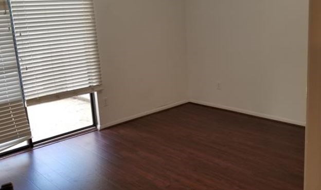 8100 Cambridge Street, Unit 89 Houston, TX 77054 - Photo 12 of 15 an empty room with wooden floor and windows