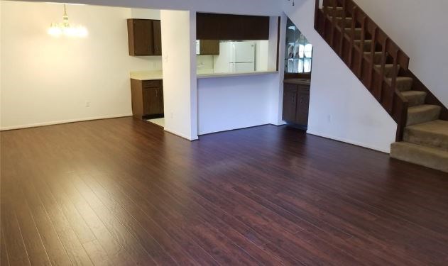 8100 Cambridge Street, Unit 89 Houston, TX 77054 - Photo 8 of 15 a view of an empty room with wooden floor and a kitchen