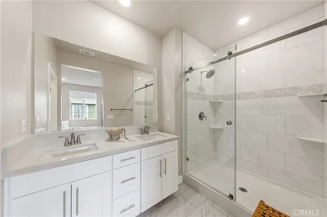 a bathroom with a shower sink double vanity and shower