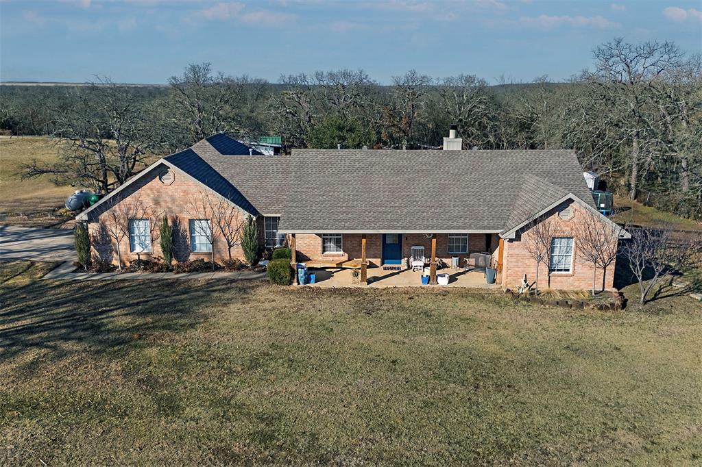 an aerial view of a house with yard and roof