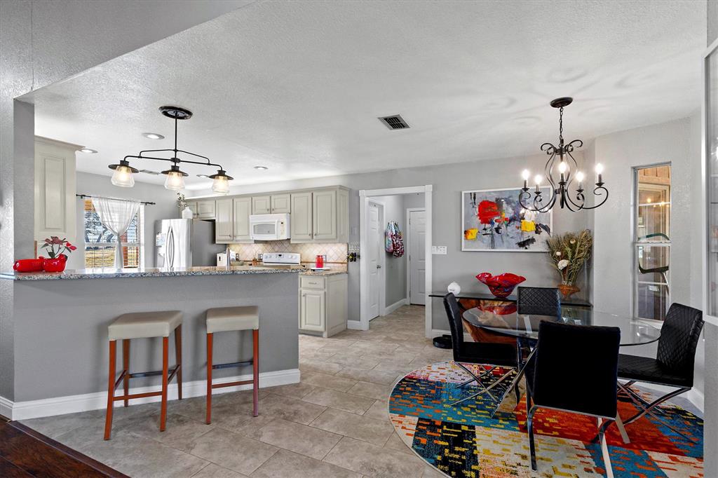 2590 Blackjack Road West Aubrey, TX 76227 - Photo 16 of 26 a living room with kitchen island furniture and a chandelier