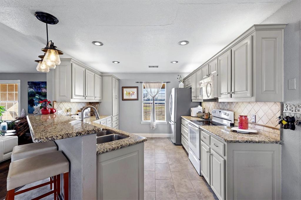2590 Blackjack Road West Aubrey, TX 76227 - Photo 17 of 26 a kitchen with sink refrigerator and cabinets