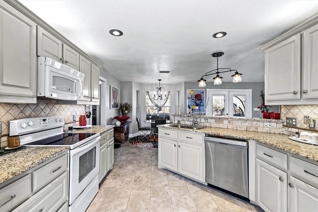 2590 Blackjack Road West Aubrey, TX 76227 - Photo 18 of 26 a kitchen with lots of counter top space appliances and cabinets
