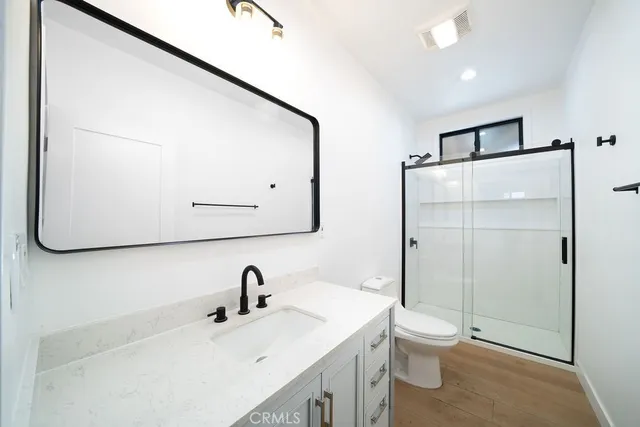 a bathroom with a sink a toilet and shower