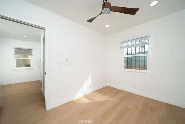 an empty room with a window and ceiling fan