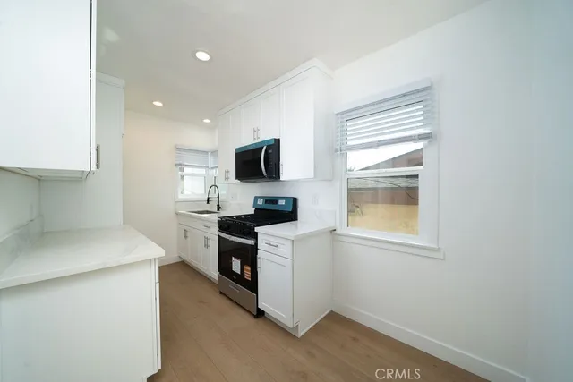 a kitchen with a stove a sink and a microwave