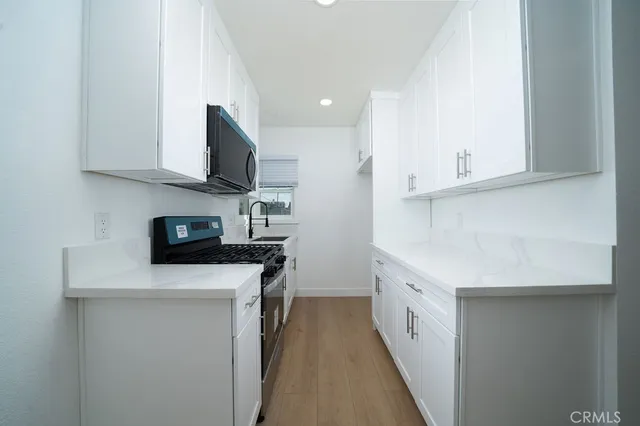 a kitchen with stainless steel appliances a sink dishwasher stove refrigerator and microwave