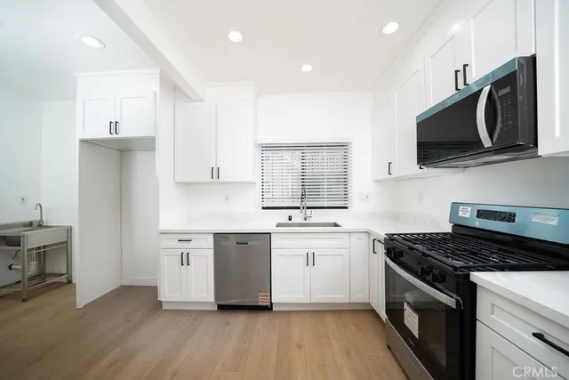 a kitchen with stainless steel appliances a sink stove and microwave