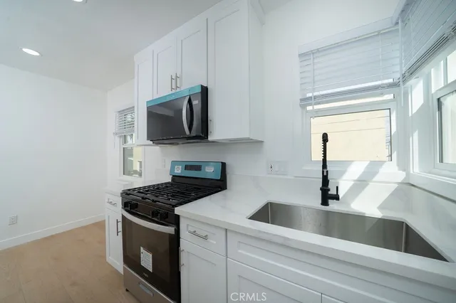 a kitchen with granite countertop a sink and a stove top oven