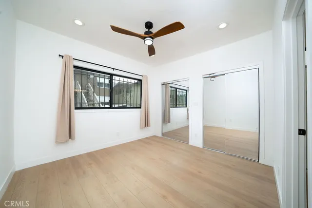 a view of a livingroom with a ceiling fan & hardwood floor
