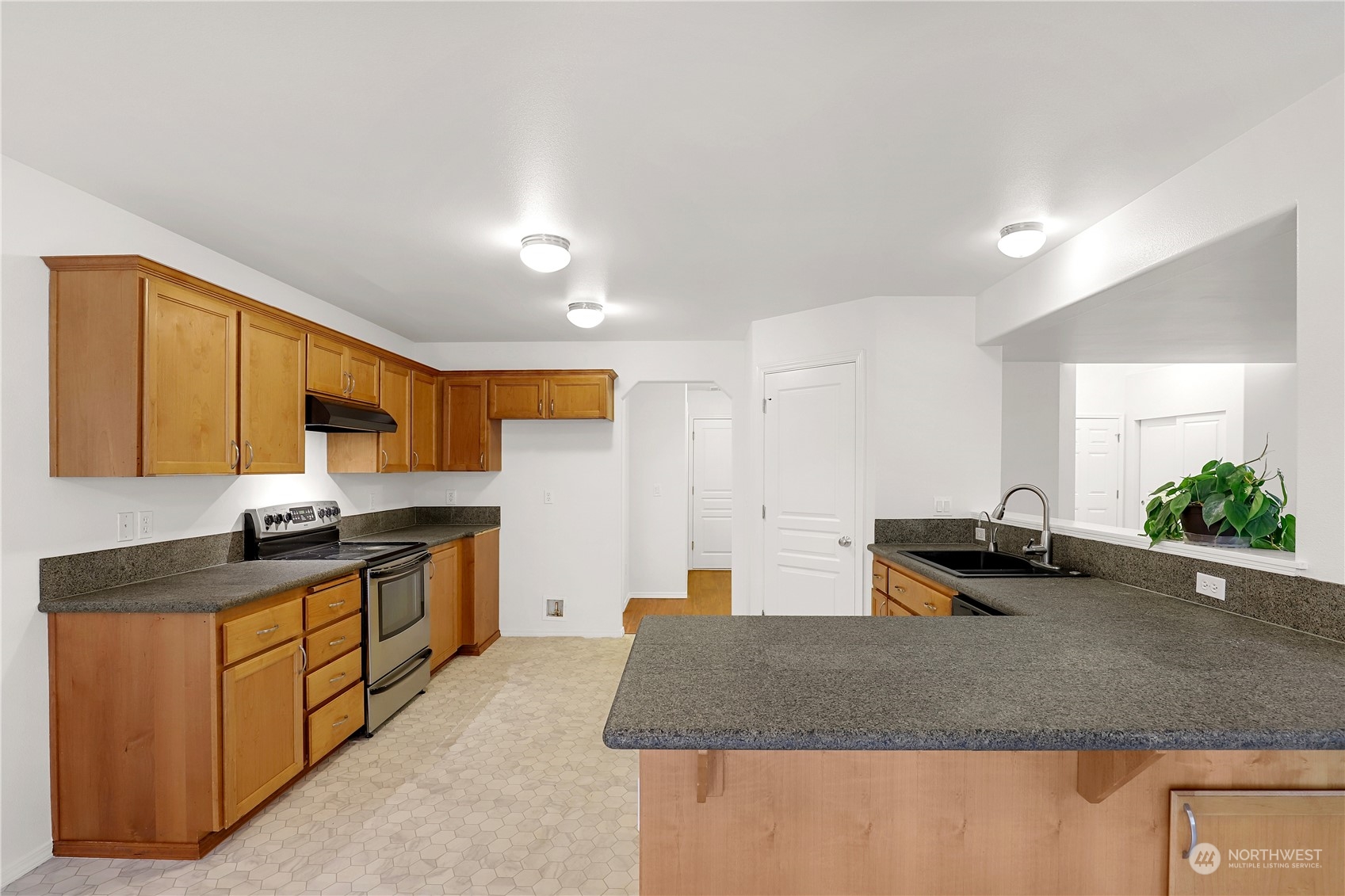 5600 55th Loop Southeast Olympia, WA 98513 - Photo 6 of 33 a kitchen with granite countertop a sink and a stove top oven
