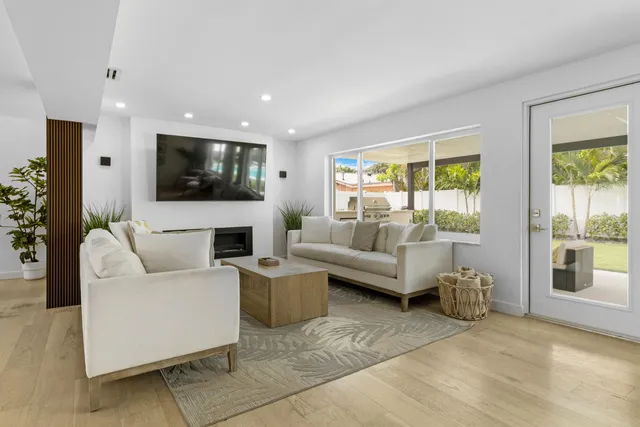 a living room with furniture a flat screen tv and a fireplace