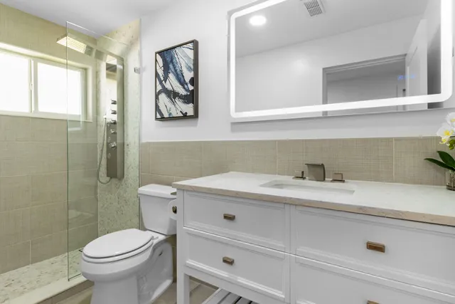 a bathroom with a sink a toilet and a mirror