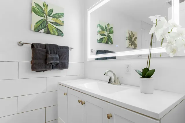 a bathroom with a sink a mirror and vanity