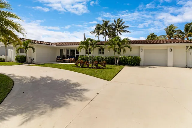 a front view of a house with a yard and potted plants