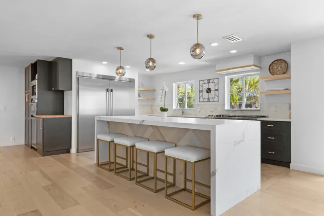 a kitchen with granite countertop a center island a sink stainless steel appliances and cabinets