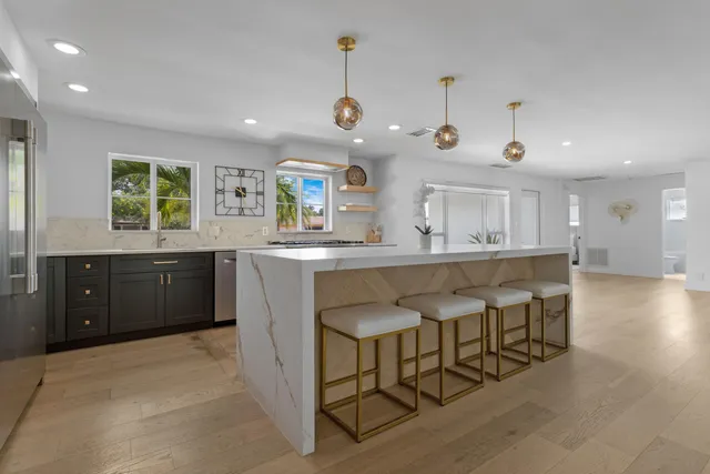 a kitchen with granite countertop a sink counter space and stainless steel appliances