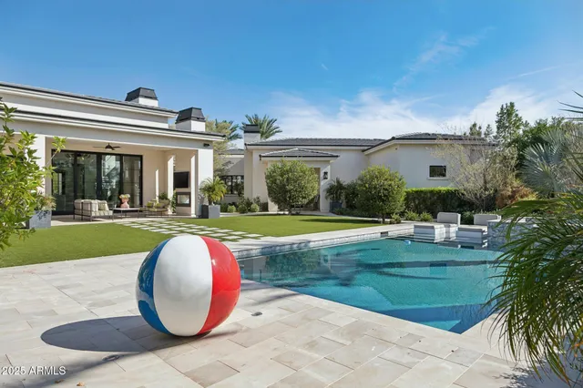a view of swimming pool with outdoor seating and a garden