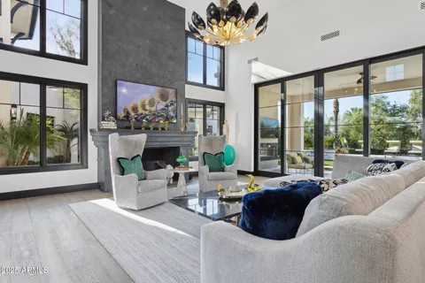 a living room with fireplace furniture and a large window