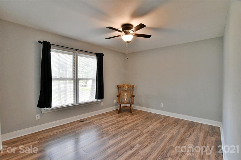 8108 Barncliff Road Charlotte, NC 28227 - Photo 20 of 25 a view of an empty room with a window and wooden floor