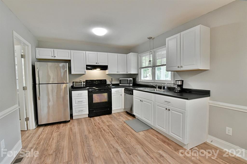 8108 Barncliff Road Charlotte, NC 28227 - Photo 10 of 25 a kitchen with granite countertop a refrigerator stove top oven and sink