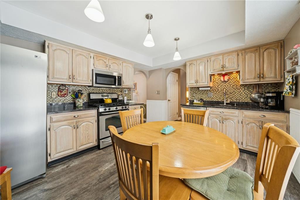3151 Seneca Court Gibsonia, PA 15044 - Photo 5 of 38 a kitchen with stainless steel appliances granite countertop a stove a sink dishwasher a refrigerator a microwave oven with white cabinets and wooden floor