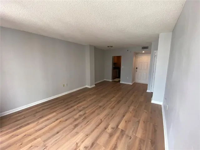 a view of a big room with wooden floor and windows