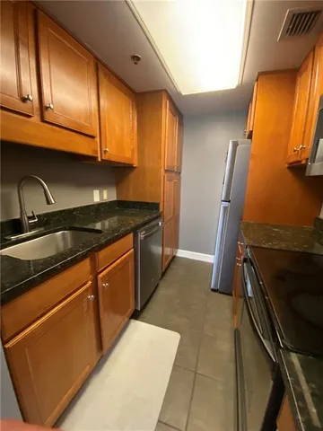 a kitchen with stainless steel appliances granite countertop a sink stove and cabinets