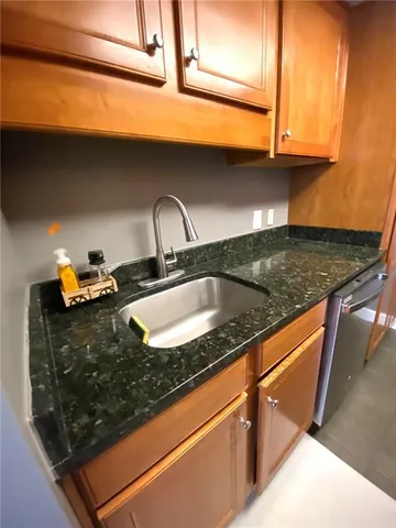 a kitchen with granite countertop a sink and a stove