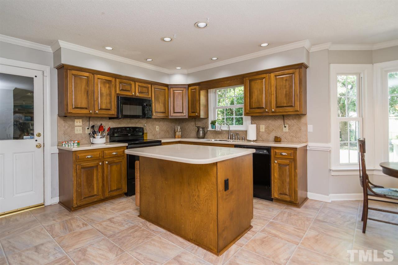 5912 Hampton Ridge Road Raleigh, NC 27603 - Photo 5 of 22 a kitchen with stainless steel appliances granite countertop a stove top oven a sink a refrigerator and a microwave