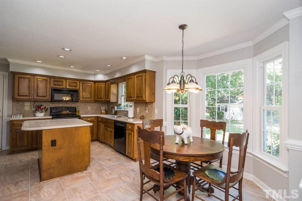 5912 Hampton Ridge Road Raleigh, NC 27603 - Photo 6 of 22 a dining room filled counter top space a stove and a chandelier