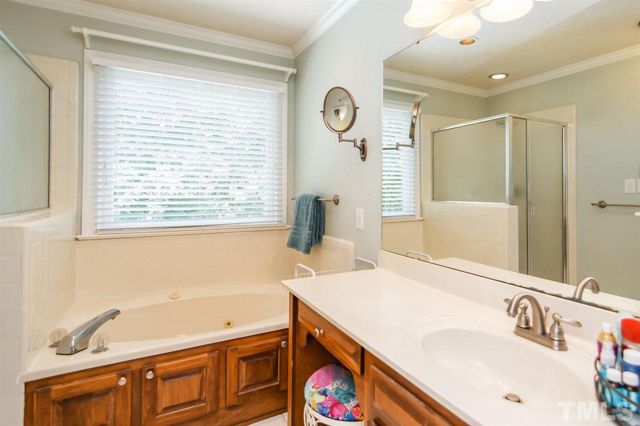 5912 Hampton Ridge Road Raleigh, NC 27603 - Photo 10 of 22 a bathroom with a tub sink and mirror