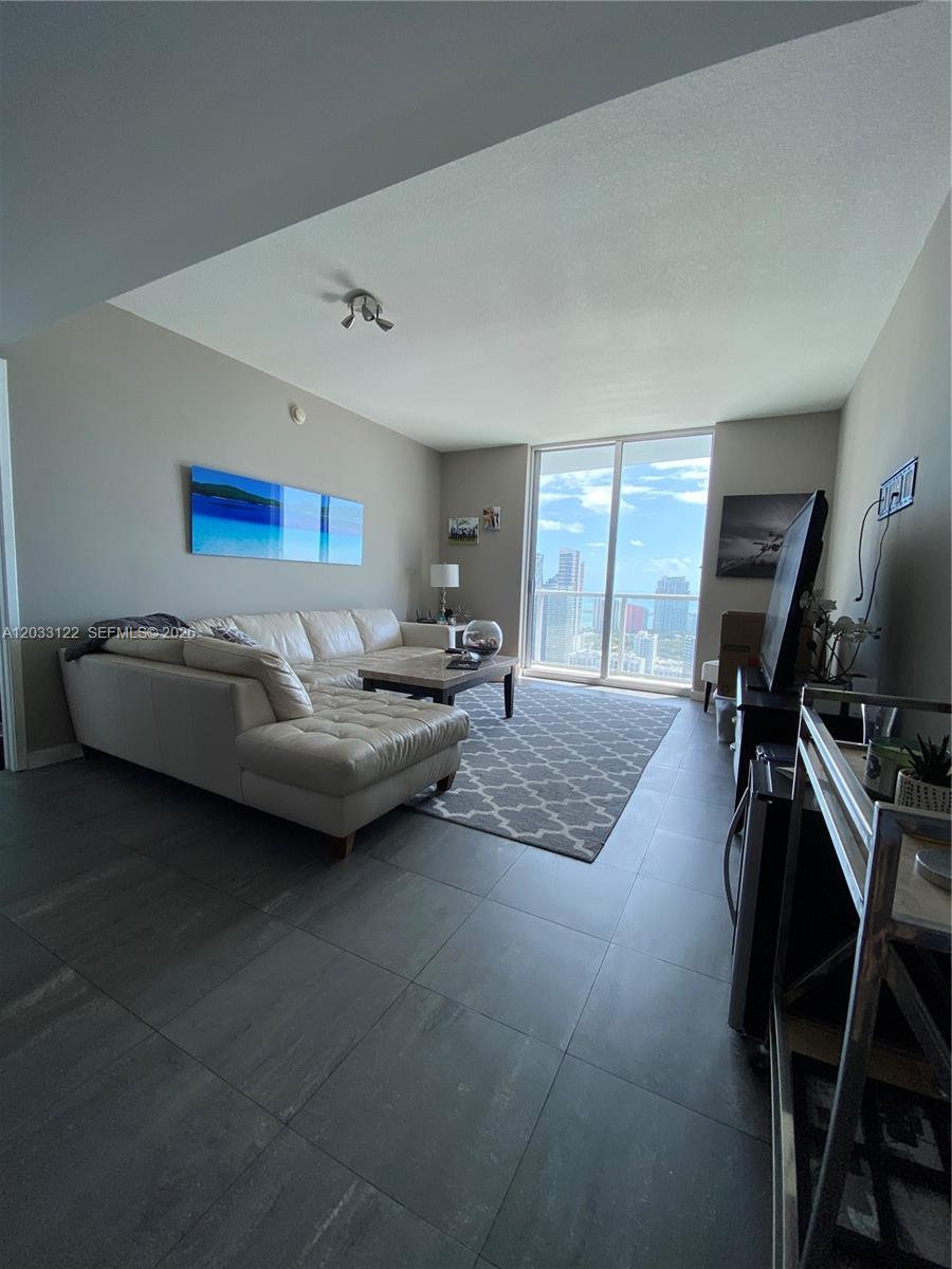 185 Southwest 7th Street, Unit 4206 Miami, FL 33130 - Photo 14 of 26 a living room with furniture and a flat screen tv