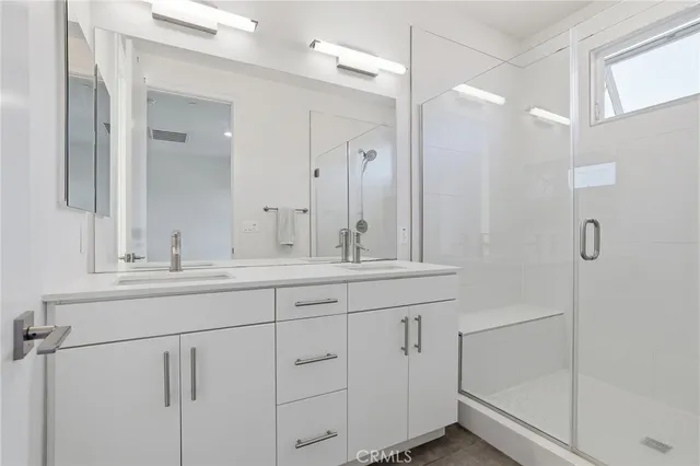 a bathroom with double sink and a mirror