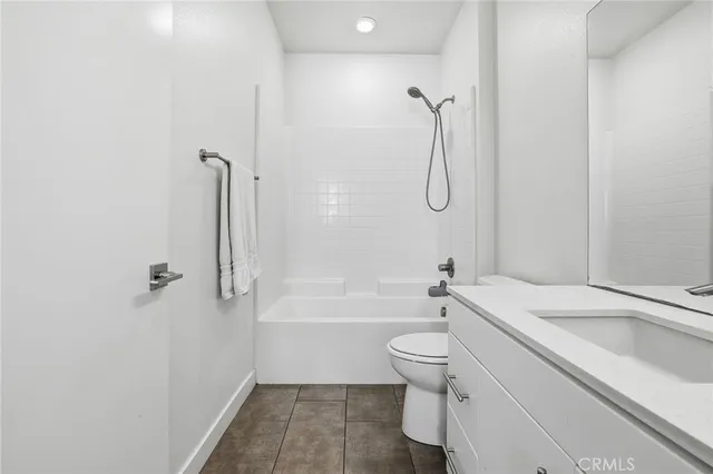 a bathroom with a granite countertop toilet a sink and a bathtub