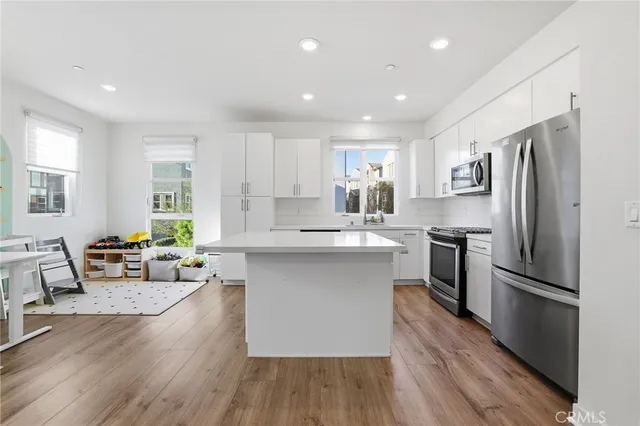 a kitchen with refrigerator a sink dishwasher a refrigerator and cabinets with wooden floor