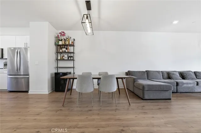 a living room with furniture a refrigerator and a table